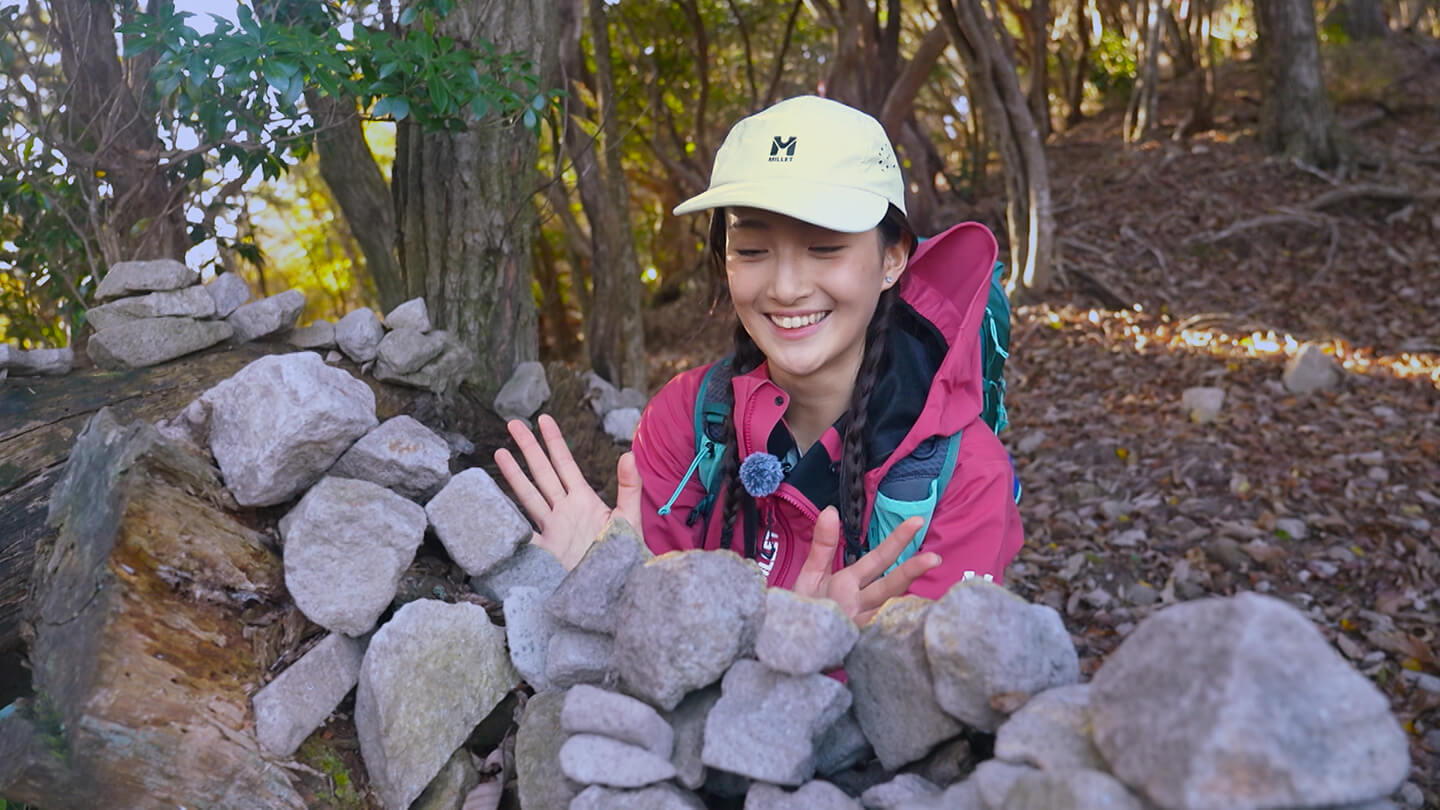 登山道中、倒木に積み上げられた大量の石を発見